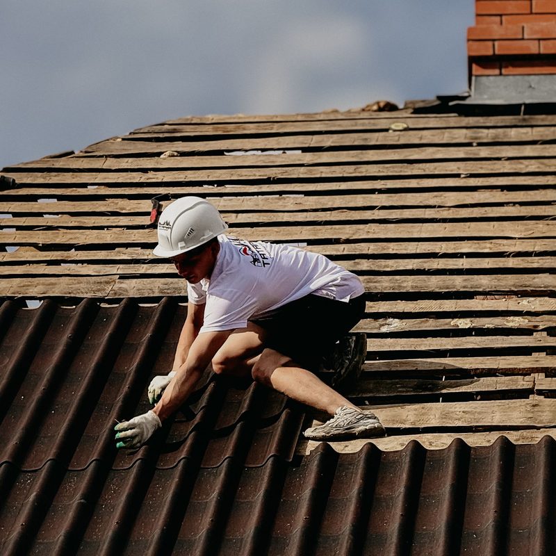 Roofer installing tiles with safety gear