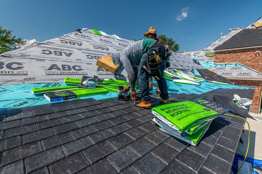 Synthetic slate roof being installed on a brick home
